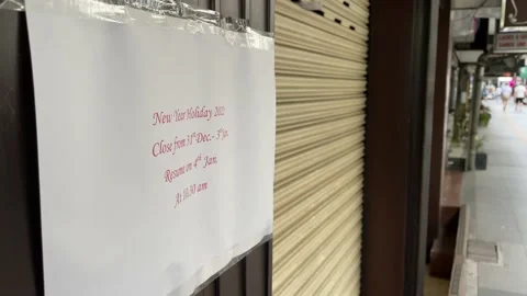 Closed sign at storefront during New Year holiday with pedestrian walking - day Video stock 197100786
