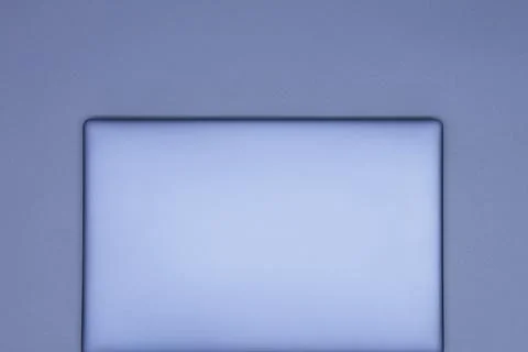 Closed silver laptop on a gray background. Top view. Stock Photos