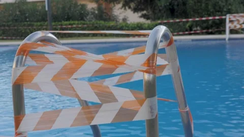 Closed slide in public swimming pool during coronavirus pandemic, caution tape Stock Footage 143648155
