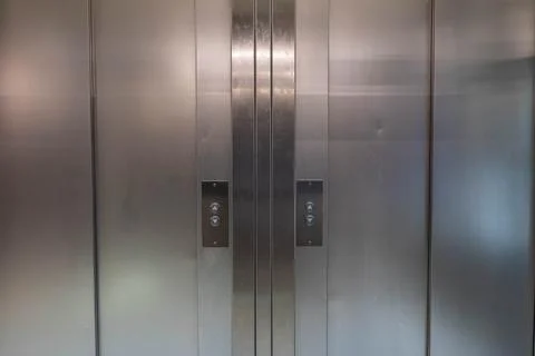 Closed stainless steel elevator doors in a modern interior setting Stock Photos