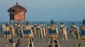 Closed umbrellas and chairs on the beach at sunset HD Footage