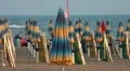 Closed umbrellas and chairs on the beach at sunset HD Footage