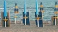 Closed umbrellas and chairs on the beach at sunset HD Footage