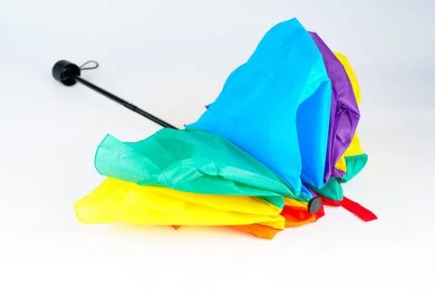 Closed vibrant multi-colored rainbow umbrella isolated on white background Stock Photos