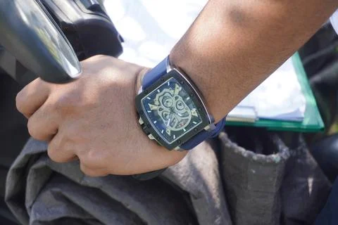 Closed up the watch on the left hand holding the motorcycle handlebars 스톡 사진