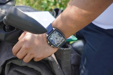 Closed up the watch on the left hand holding the motorcycle handlebars 스톡 사진