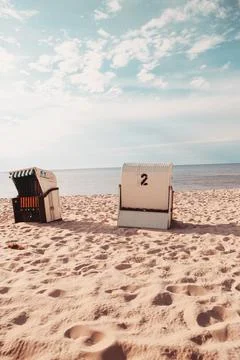 Closed wicker beach chairs on empty sandy beach at Baltic Sea Photos