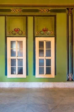 Closed windows and beautiful elegant carved frames on green wall with orna... Stock Photos