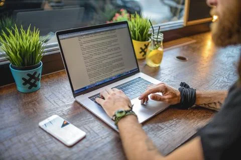 Closely man experienced associate web editor reading article on site via lapt Stock Photos
