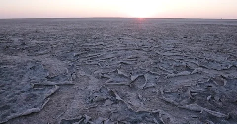 Closep-up panning view of large areas of dry cracked mud highlighted by the Stock Footage 78211610