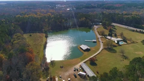 Closer aerial drone view fly up to green lake with sun shadow. Stock Footage 170441248