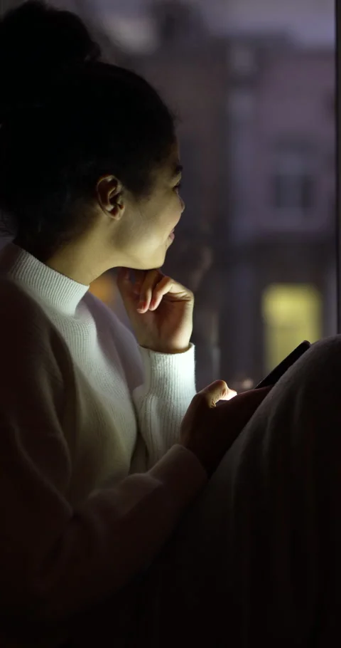Closer to friends. Side view of young mixed race woman using smartphone Stock Footage