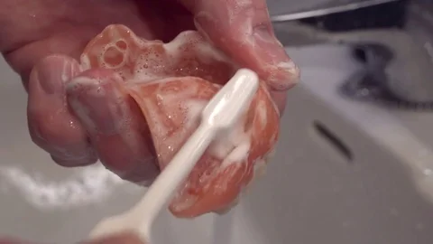Closer look of the brushing of teeth dentures Stock Footage 76363912