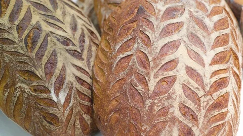 Closer look of the leaf design on the brown bread Stock Footage 98616120