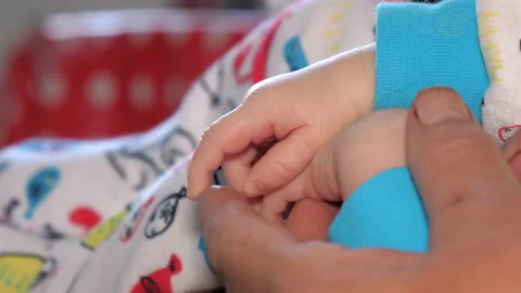Closer look of the tiny hands of the baby .4K Stock Footage 135596672