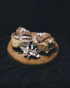 Closer view of two cinnamon rolls on a wooden surface. Stock Photos