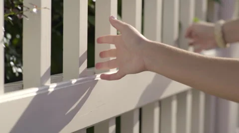 Closeup Of 2 Teens' Hands, As They Graze Past A White Fence Stock-Footage 57972177