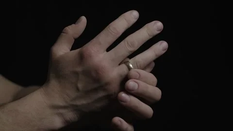 Closeup 4k slow motion video af mans hands putting on his ring on a black Stock Footage 264767809