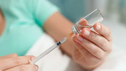Closeup 4k video of young woman with diabetes filling insulin syringe from Stock Footage
