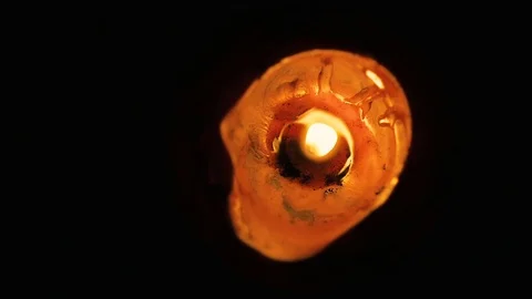 Closeup abstract of a large, lone wax candle burning view from the top. Video stock 84653901