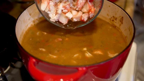 Closeup, adding king crab meat to a pot of gumbo stew Stock Footage 92577389