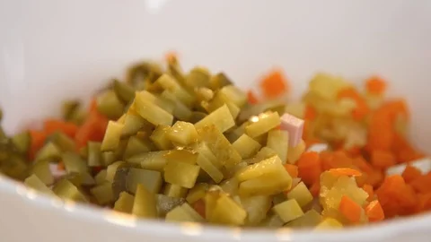 Closeup adding pickle into white bowl with carrot and potatoes Stock Footage 121749830