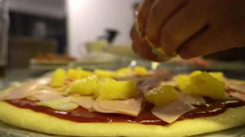 Closeup adding pineapple chunks on a homemade pizza and preparing it in the Stock Footage 193022668