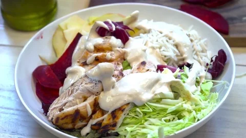 Closeup of adding sauce to the fresh green salad slow motion Video stock 77038048