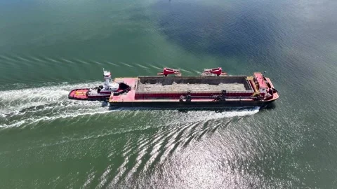 Closeup Aerial view of a dredge container being pushed by a tugboat Stock Footage 276240864