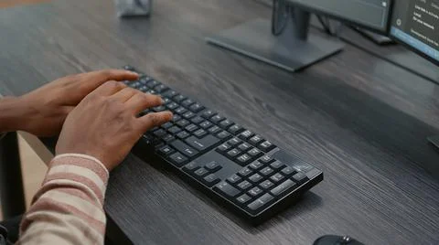 Closeup of african american programer hands typing code on keyboard while Foto stock