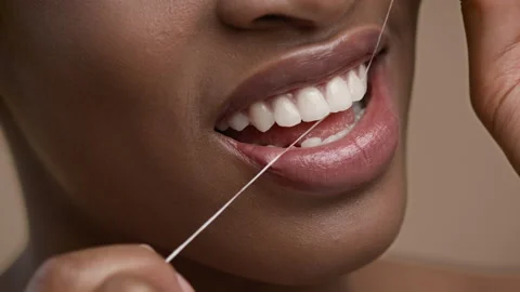 Closeup Of African American Woman Flossing Teeth Over Beige Background Stock Footage
