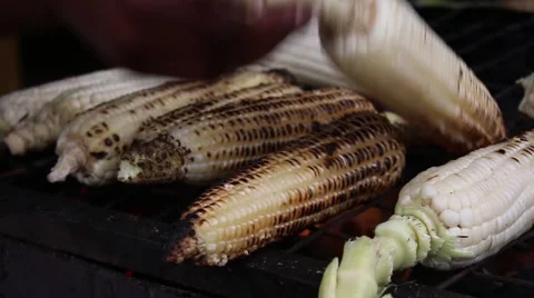 Closeup of african hand flipping the corn roasting on grill Stock Footage 47885904