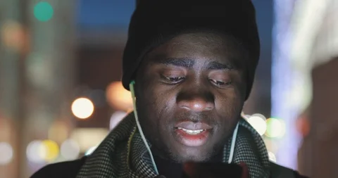 Closeup of african man using phone app at night Stock Footage 103032630