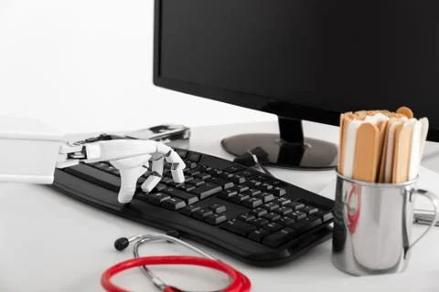 Closeup of an ai robotic hand, using a keyboard Fotos Stock