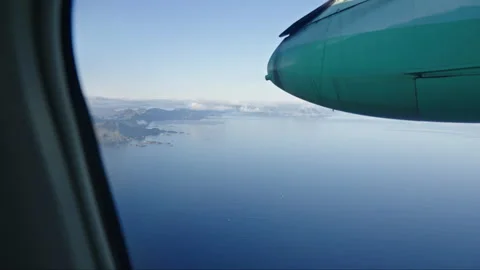 Closeup of an aircraft engine with the ocean and mountains below Stock Footage 268412889