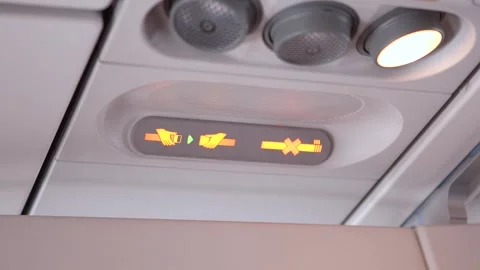 Closeup airplane cabin control showing illuminated seatbelt and no smoking signs Stock Footage 293502425