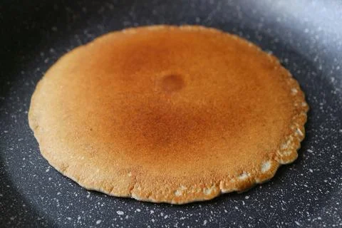 Closeup of an almost ready fried plain pancake in fry pan 스톡 사진