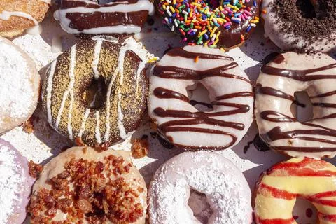 Closeup angled image of fresh made store bought donuts in paper box fresh out Stock Photos