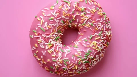Closeup appetizing rotating crimson doughnut with pastry topping isolated. 4k Video stock 152762267