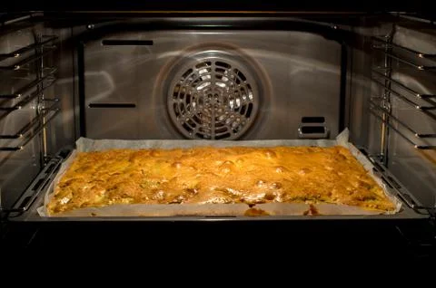 Closeup of apple cake in baking tin in open oven Foto stock