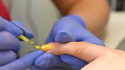Closeup of applying yellow polish on the base coat. Manual manicure  Stock Footage 90277626