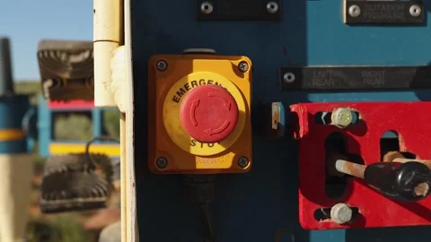 Closeup arcing dolly shot of red emergency stop button on drilling rig Stock Footage 302523349