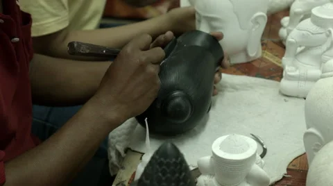 Closeup of an artisan cleaning up a ceramic Buddha head Stock Footage 48027314
