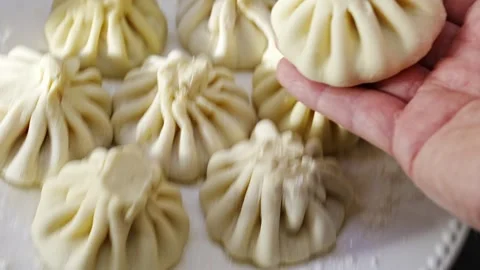 Closeup of artisan shaping dough parcels, raw flourcoated dumplings 스톡 동영상 321453656