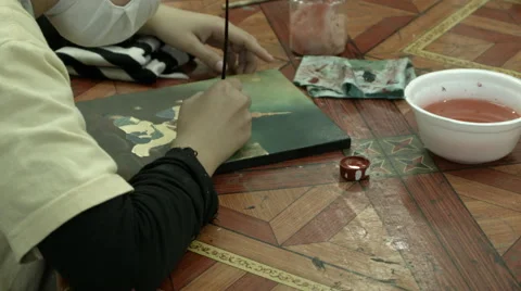 A closeup of an artists hands as she paints an oil on canvas Stock Footage 48029458