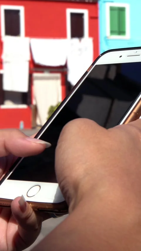 Closeup of asian hand using smartphone in street of Burano island. Venice Stock Footage 331768450