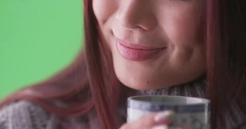 Closeup of asian woman holding a cup of tea on green screen Stock Footage