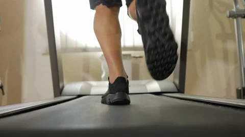 Closeup athletic feet running on treadmill in fitness gym. Low view sneakers Stock Footage 119598564