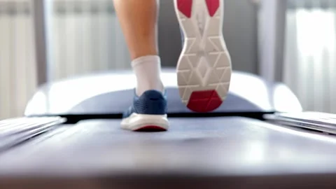 Closeup athletic feet running on treadmill in fitness gym. Back view. Low view Stock Footage 139747448