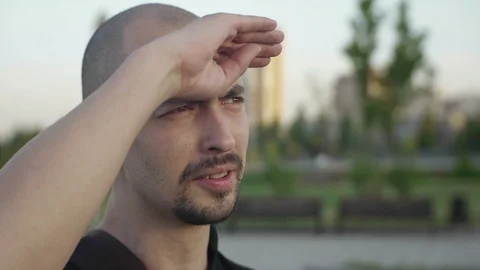 Closeup of an attractive bald man with a beard looking into the distance with Vídeo Stock 89878353